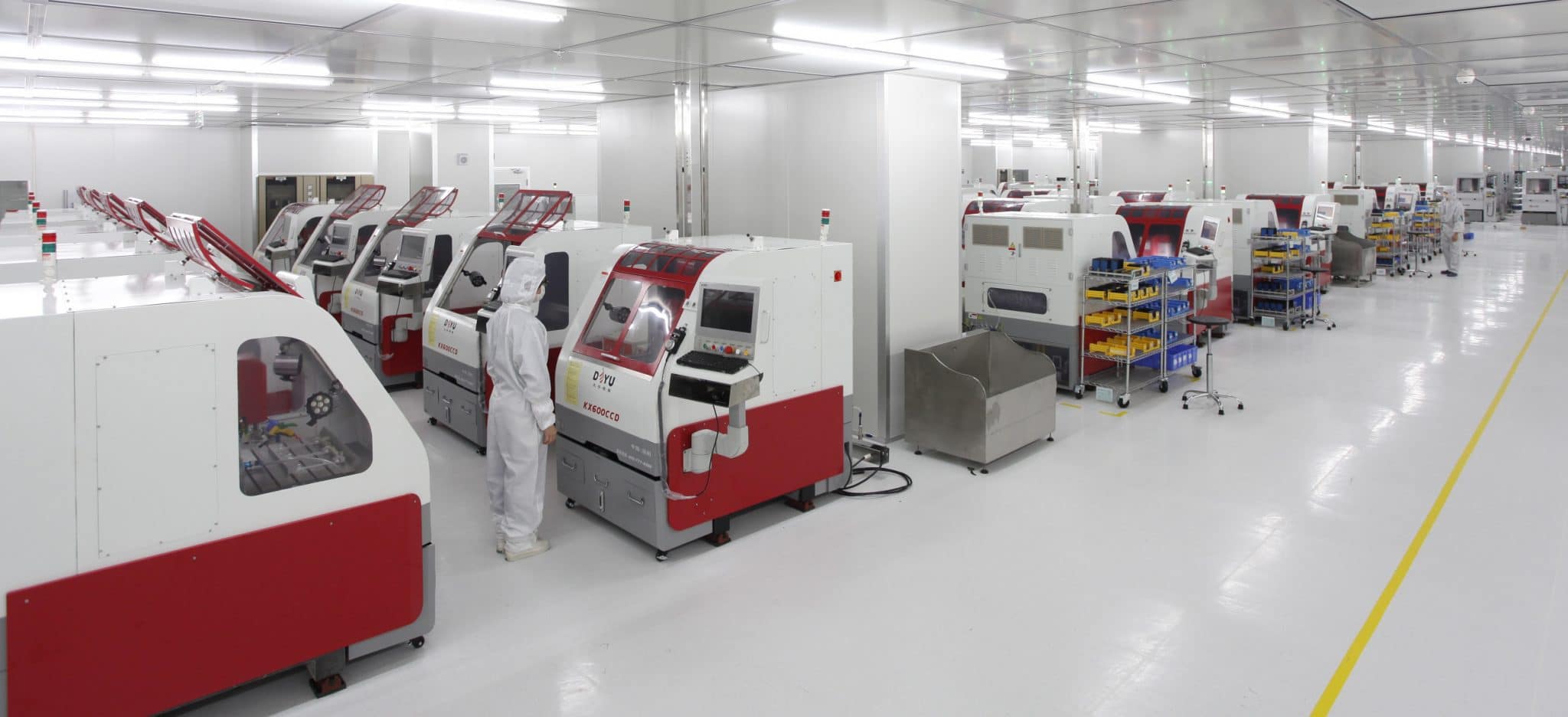 Orient Display cleanroom bonding line, with rows of bonding machines and operators in cleanroom suits